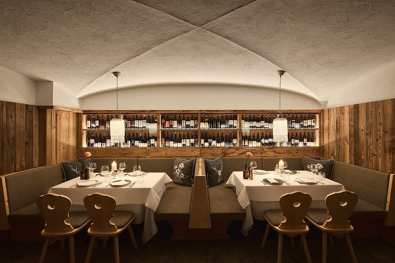 The vaulted dining room with wooden benches and wine shelves